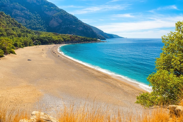 Bela praia de Kidrak com praia de areia e água azul perto da cidade de Oludeniz, na costa da região de Mugla, na Turquia