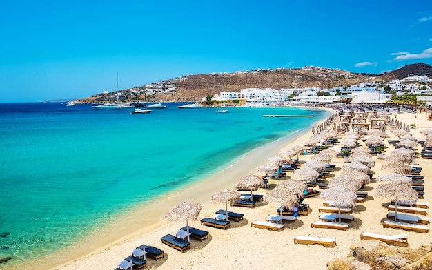 Bela praia de mykonos com espreguiçadeiras e guarda-sóis grécia