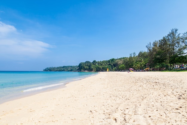 Foto bela praia de surin na cidade de choeng thale, phuket, tailândia, com areia branca, água turquesa e palmeiras