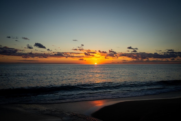 Foto bela praia de verão pôr do sol céu e nuvens