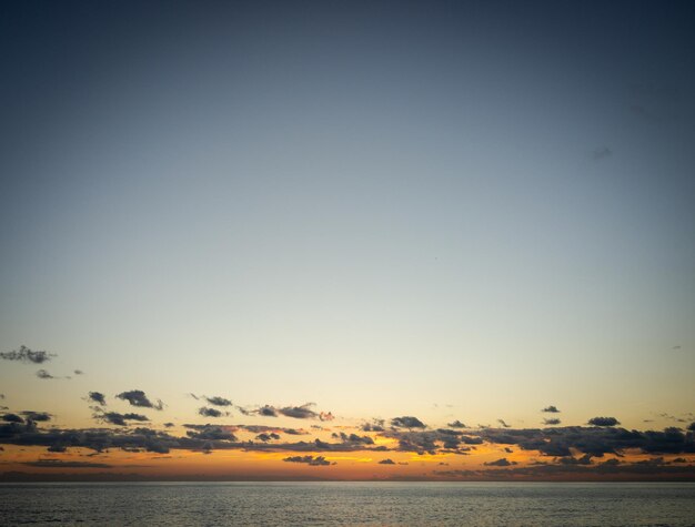 Foto bela praia de verão pôr do sol céu e nuvens