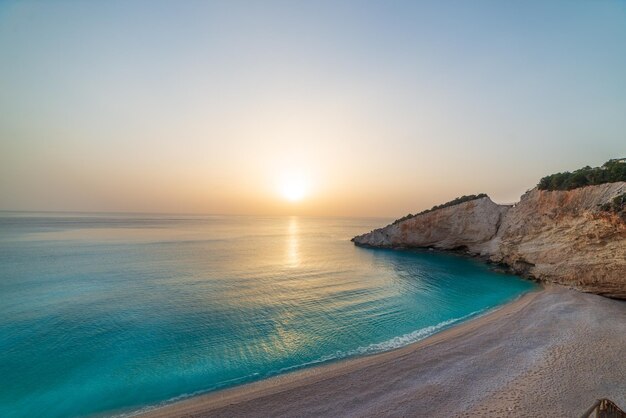 Foto bela praia e baía de água na grécia linha costeira espetacular pôr-do-sol céu lindo sobre a água azul penhascos rochosos únicos grécia verão top destino de viagem ilha de lefkada