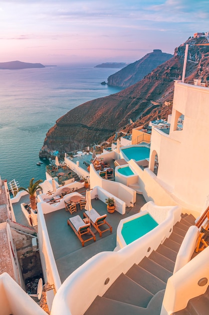 Bela Santorini pelo terraço ao pôr do sol na Grécia. Vista romântica, férias em casal, destino famoso