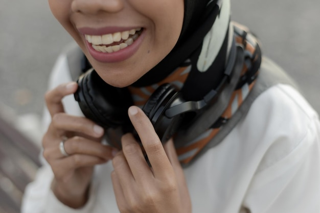 bela senhora muçulmana asiática casual usando fone de ouvido e ouvindo música