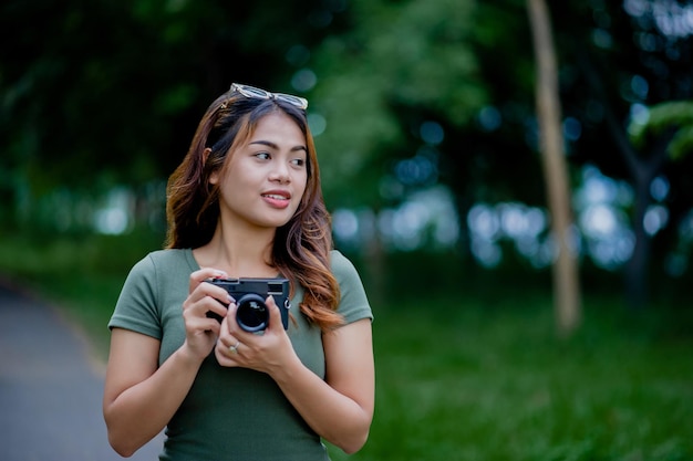 Bela turista asiática e sua câmera pessoal fotógrafa mulher Surround Milleles
