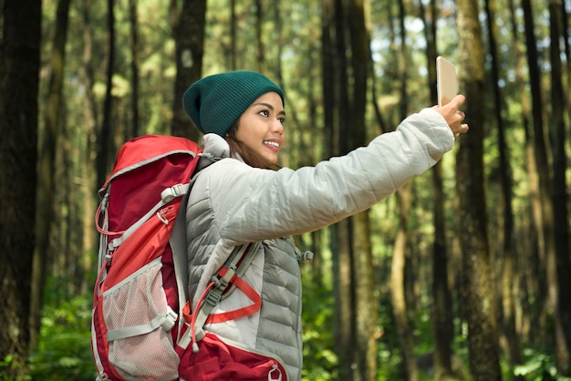 Bela turista asiática tomando selfie com seu telefone