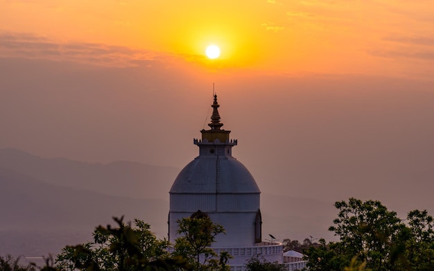 Bela vista da paisagem do sombrio nascer do sol e stupa da paz mundial em Pokhara Nepal