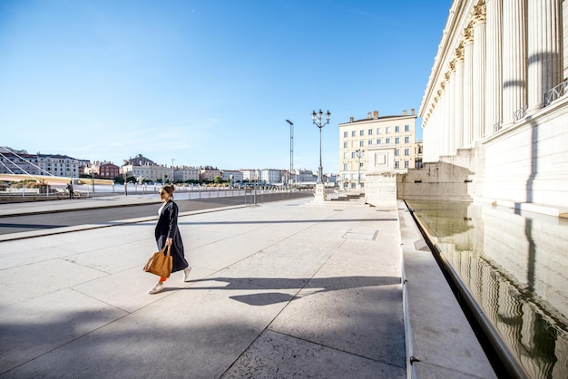 Bela vista da praça com uma mulher caminhando perto do palácio das 24 colunas na cidade de Lyon