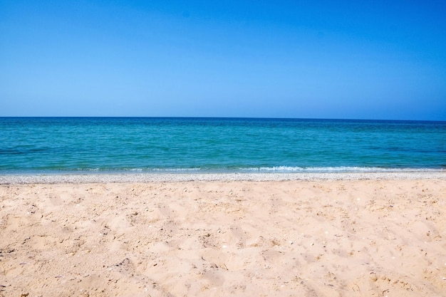 Bela vista da praia de areia e mar em dia ensolarado