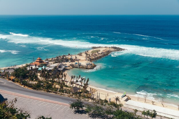 Foto bela vista da praia de melasti. mar azul com ondas, céu claro e areia branca.