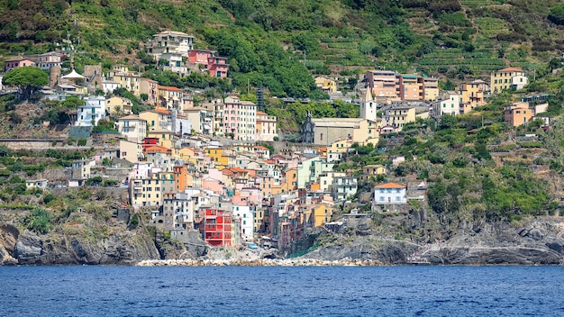 Bela vista das casas coloridas de Riomaggiore no dia ensolarado de mar. Itália
