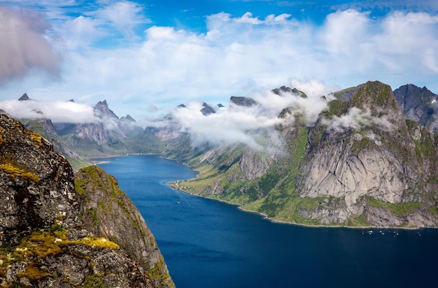 Bela vista das nuvens sobre as montanhas cobertas de grama e água na Noruega