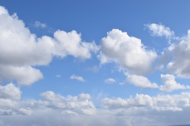 Bela vista de nuvens fofas brancas em um céu azul - perfeito para papel de parede