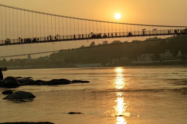 Bela vista do aterro do rio Ganges e ponte ao pôr do sol Rishikesh Índia