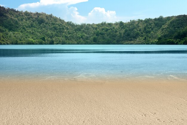 Foto bela vista do lago com colina e fundo de céu azul