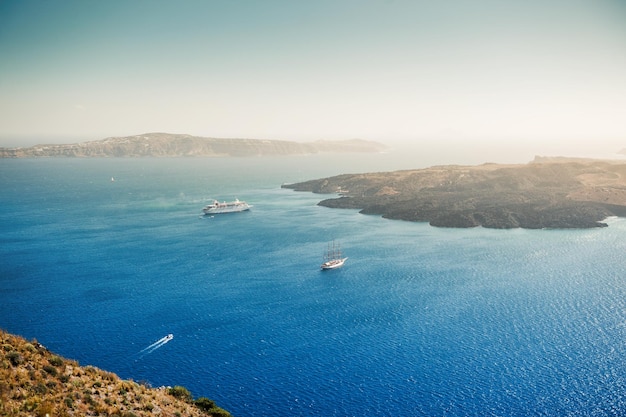 Bela vista do mar e das ilhas ao pôr do sol. Céu azul e mar azul. Ilha de Santorini, Grécia. Efeito de tom criativo