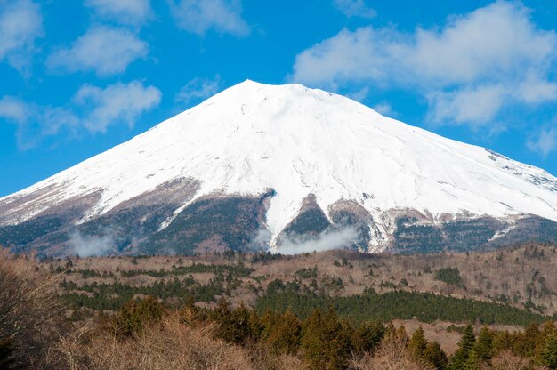 Bela vista do Monte Fuji coberto de neve no inverno com céu azul e nuvens brancas.