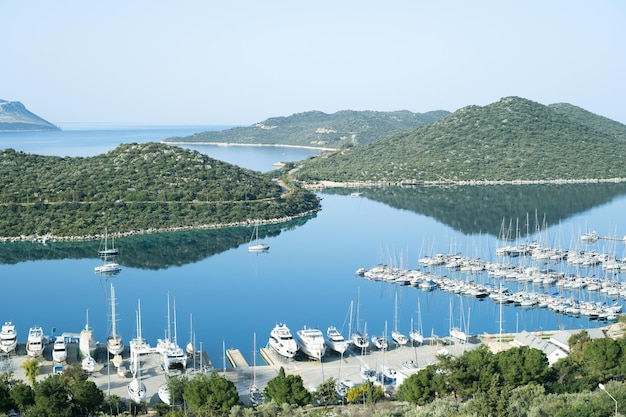 Bela vista na marina de barcos e iates Montanhas verdes da ilha na água calma do espelho azulPaisagem marinha de tirar o fôlegoCosta Calma Tranquilidadebeleza no conceito da naturezaCopyspace