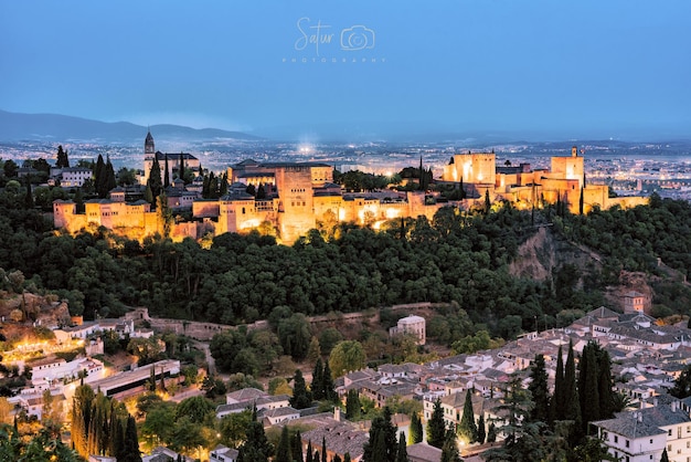 Foto bela vista panorâmica da cidade de granada com o palácio de alhambra iluminado.