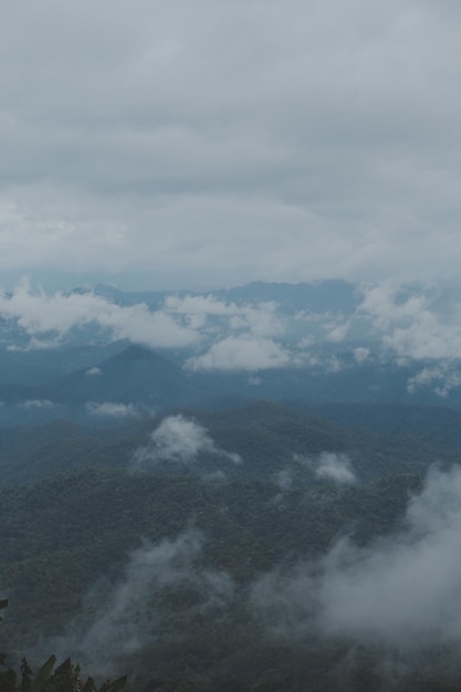 Bela vista panorâmica de neblina e nuvens em camadas distantes montanhas com céu azul de manhã