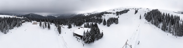 Bela vista panorâmica de um ponto alto na base de esqui com funiculares em um dia nublado de inverno