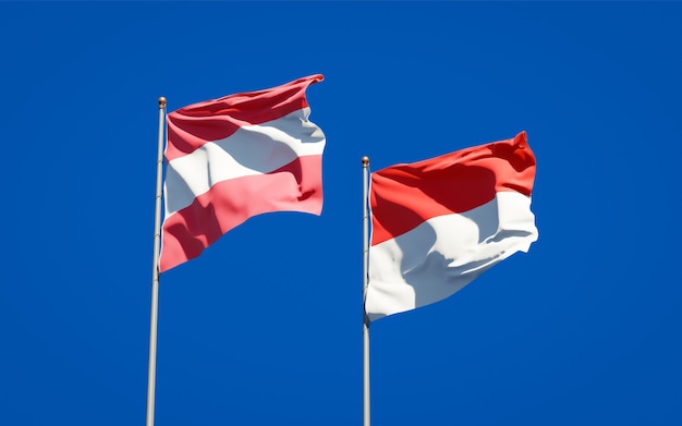 Belas bandeiras de estados nacionais da Indonésia e da Áustria juntas no céu azul