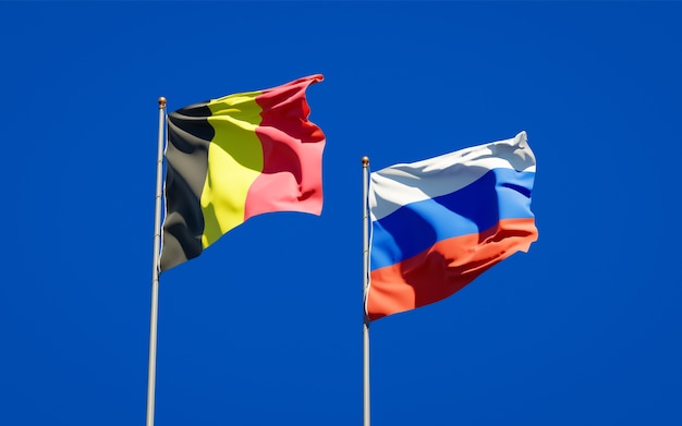 Belas bandeiras do estado nacional da Rússia e da Bélgica juntos no céu azul. Arte 3D