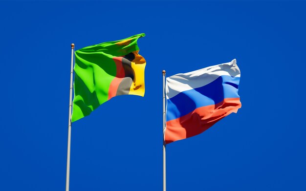 Belas bandeiras do estado nacional da Zâmbia e da Rússia juntos no céu azul. Arte 3D