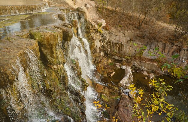 Foto belas cachoeiras entre grandes rochas na floresta de outono do parque sofievskiy em uman, ucrânia