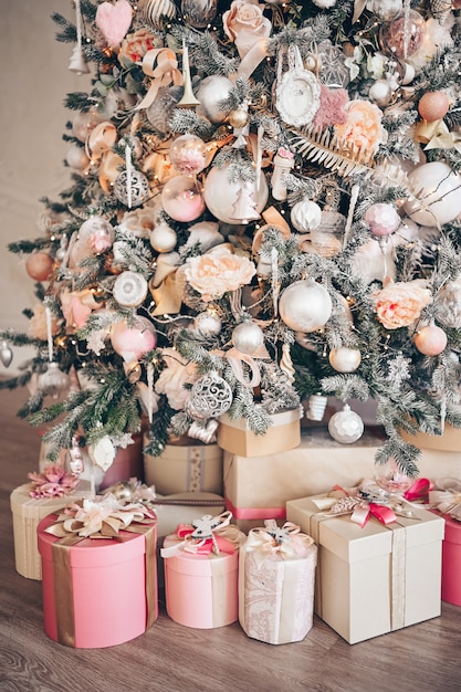 Belas caixas de presente de Natal no chão perto de abeto na sala