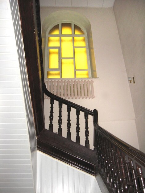 Belas escadas de madeira com janela na casa.