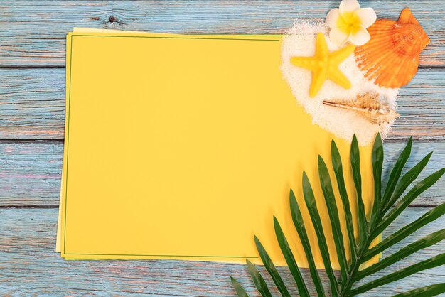 Foto belas férias de verão, acessórios de praia, conchas, areia e palma deixam no papel