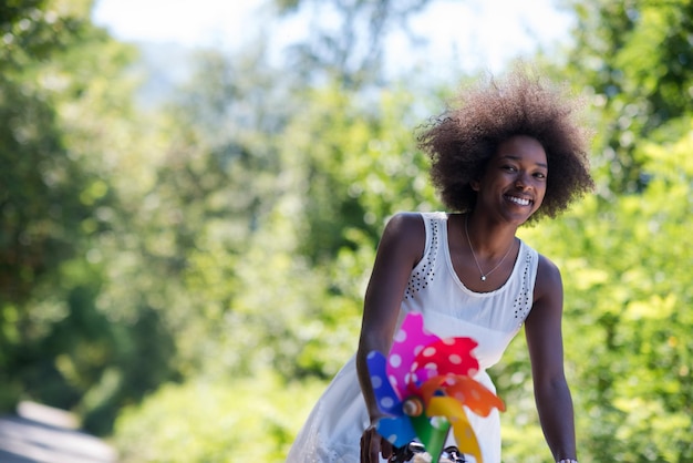 belas jovens afro-americanas desfrutam enquanto andam de bicicleta na floresta em um dia ensolarado de verão