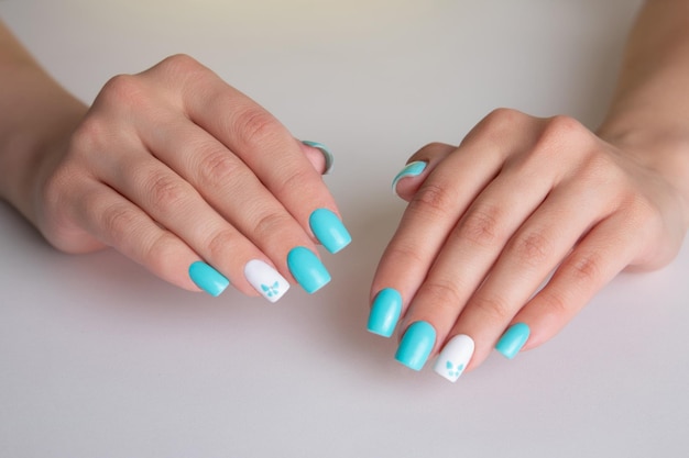 Foto belas mãos femininas com manicure romântico unhas azul e branco gel polonês