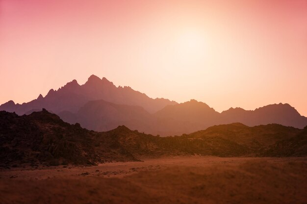 Foto belas montanhas no deserto da arábia ao pôr do sol. paisagem de verão. efeito de tom criativo