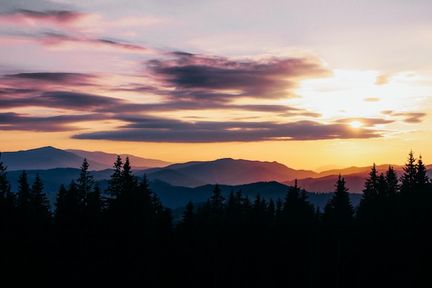 Belas montanhas pacíficas no pôr do sol no verão