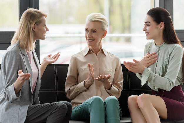 Belas mulheres de negócios a fazer gestos enquanto falam no escritório.