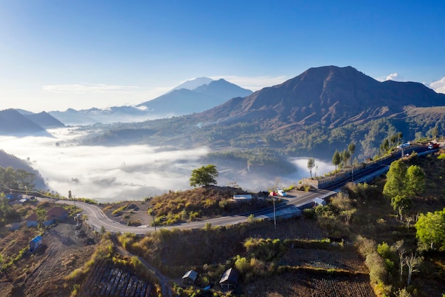 Belas paisagens aéreas da vila enevoada de Pinggan com o Monte Batur pela manhã em Bali Indonésia