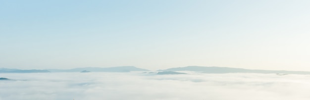 Belas paisagens das montanhas com branco nevoento pela manhã.