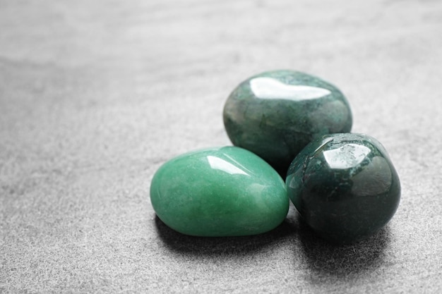 Belas pedras preciosas verdes no espaço de mesa cinza para texto