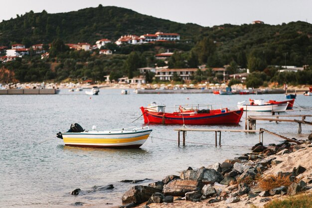 Belas vistas da costa rochosa, dos barcos de pesca e da pequena aldeia com casas e hotéis à noite na Grécia