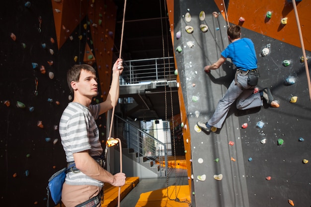 Belayer asegurando al escalador en la pared de roca interior