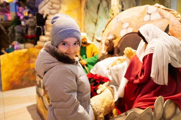 Belén de Navidad en la iglesia Baby Girl contra estable con el niño Jesús en un pesebre María y José