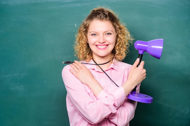 Beleuchten Sie den Prozess des Lernens Lehrer halten Tischlampe Tafelhintergrund Einsicht und Idee Hell glänzende Idee Kreativität und Inspiration Bildungsidee Wissenstag Aufklärungskonzept