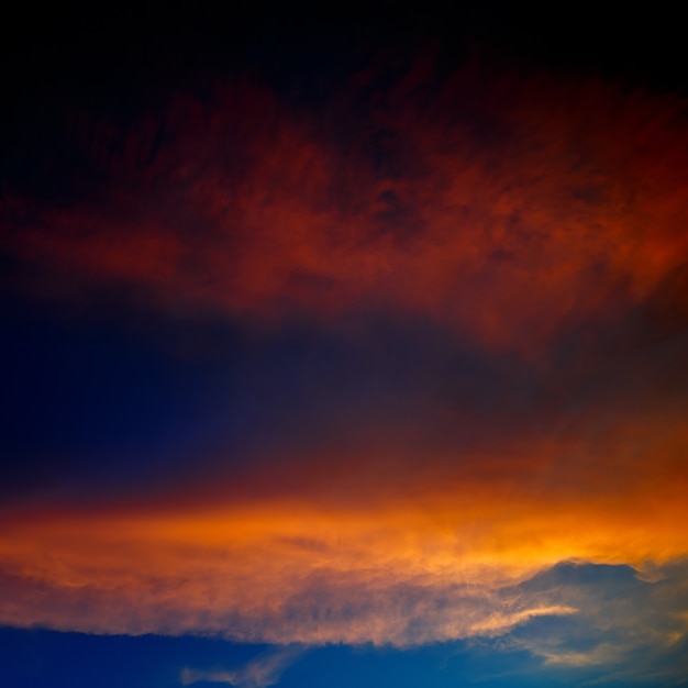 Beleuchtet von den Sonnenwolken bei Sonnenuntergang auf einem Hintergrund des blauen Himmels