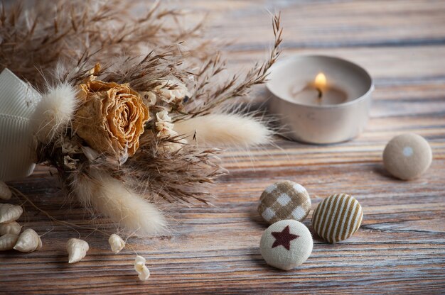 Beleuchtete Aromakerze und trockene Blumen auf rustikalem Tisch. Grußkarte für die Hochzeit