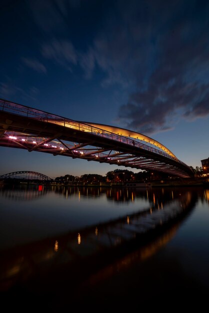 Beleuchtete Brücke über den Fluss in der Nacht