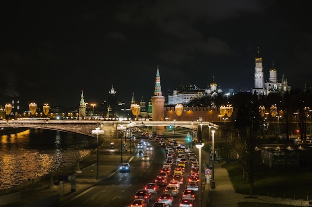 Beleuchtete Brücke über den Fluss von Gebäuden gegen den Himmel in der Nacht