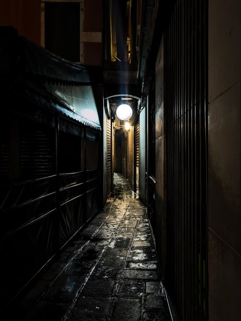 Beleuchtete Gasse inmitten von Gebäuden in der Nacht