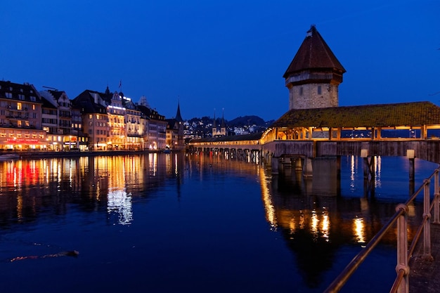 Foto beleuchtete gebäude am fluss gegen den himmel in der dämmerung